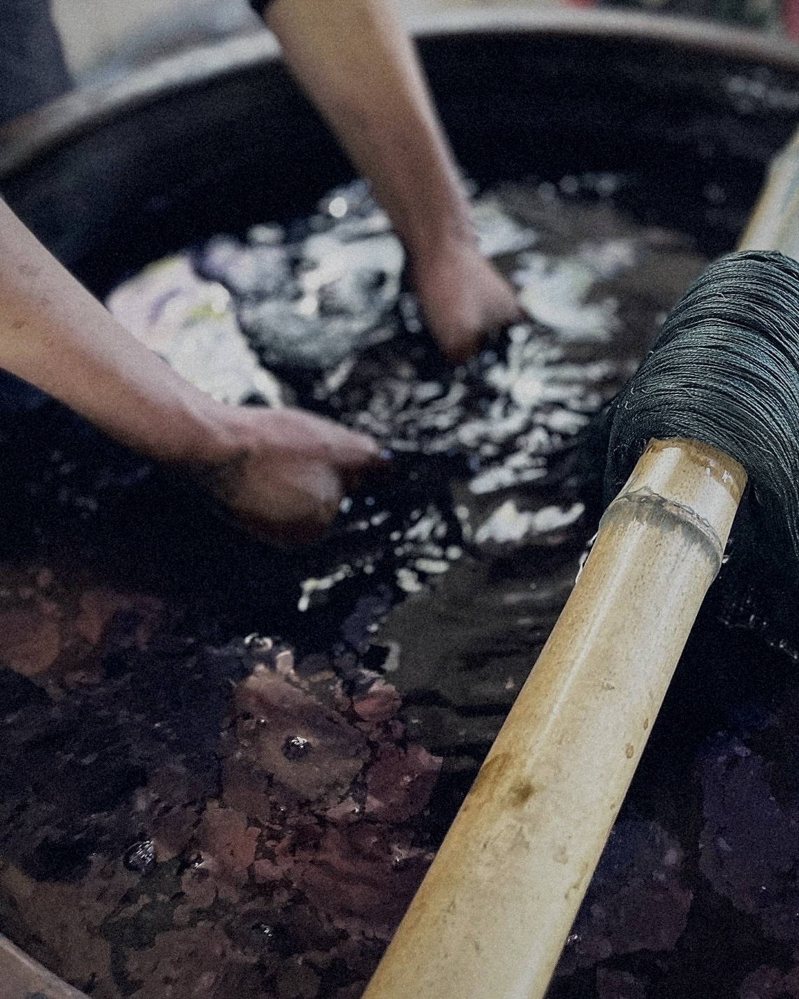 Hands and dyed thread in the indigo vat